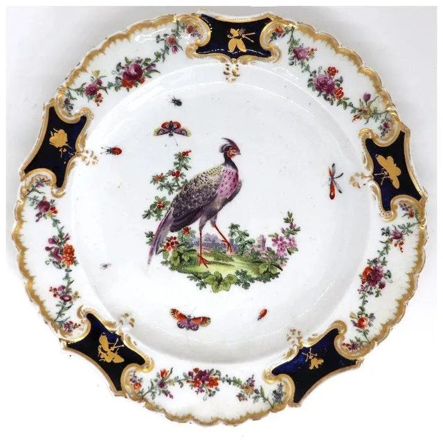 DETAILS An antique, Mecklenburg-Strelitz type plate in soft paste porcelain, with a scalloped edge, hand painted with an...
