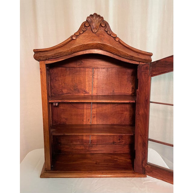 Vintage wall display cabinet has scroll and shell cornice, glass front and side panes, and gold metal knob. Original latch...