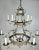 Monumental size 12-light, two-tiered silvered chandelier. The chandelier is adorned with a crown on top and cherub faces...