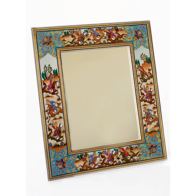 This hand-painted decorative mirror features a traditional polo scene inspired by Persian miniature painting. Horses in...