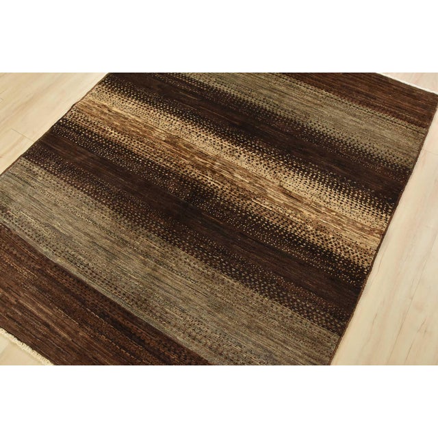 A contemporary Gabbeh rug hand-knotted with fine wool on a cotton foundation. This rug features large stripes in brown and...