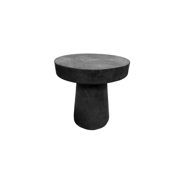 A wonderfully organic round side table. Its pigment was achieved through burning the wood multiple times and finished with...