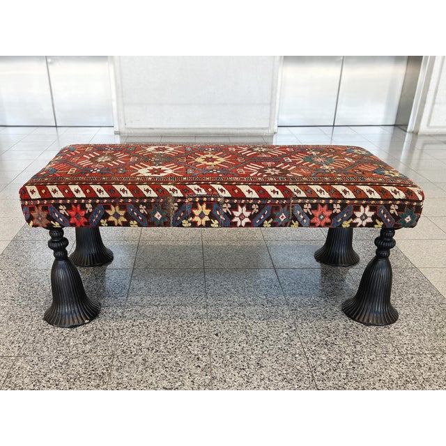 This vintage ottoman bench was made in the 1940s. The upholstery is a converted, richly patterned Kilim rug with a palette...