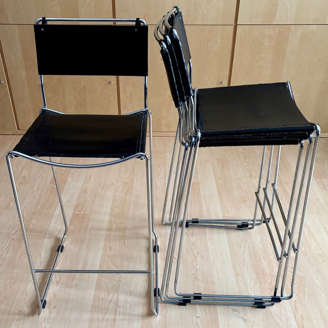 Set of four vintage modern counter height stools made of steel and leather offer high style to any space. Upholstered in...