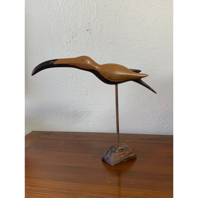 Add a touch of sculptural elegance to your home with this beautifully hand-carved vintage wooden ibis bird sculpture....