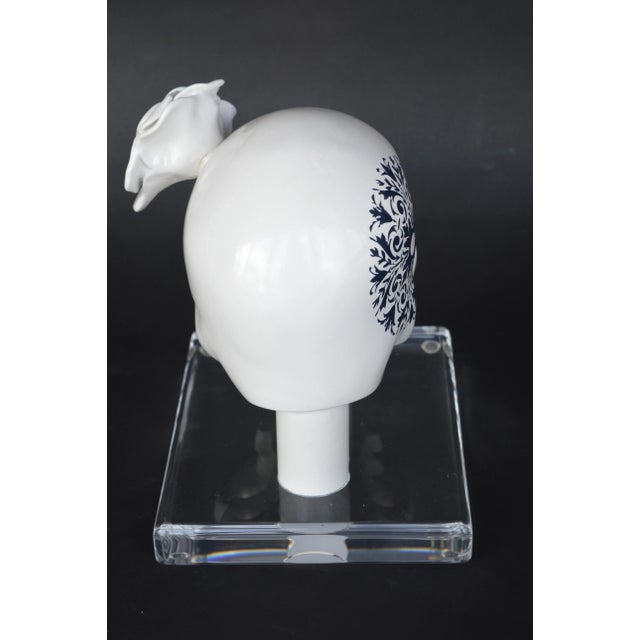 Decorative white resin skull on acrylic base.