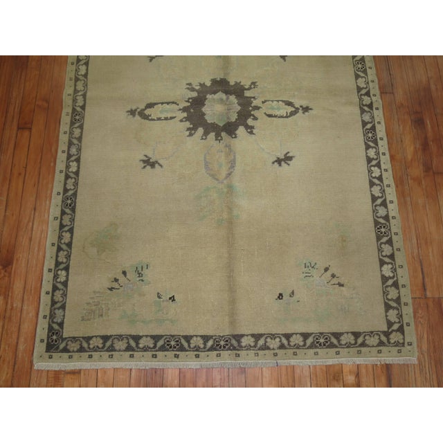 A vintage Turkish Oushak rug from the middle of the 20th century with a traditional medallion and border design in neutral...