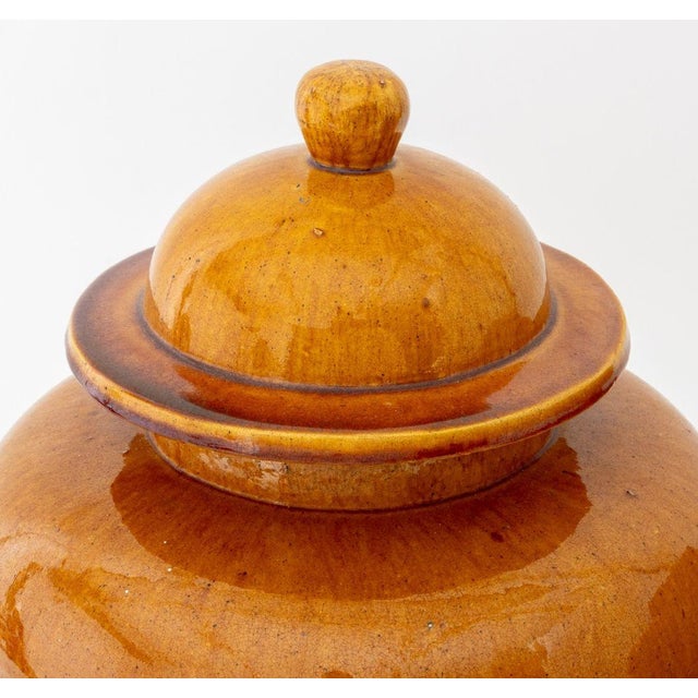 Pair of Chinese Style Butterscotch Glazed Stoneware Covered Ginger Jars. 15" H x 11" Diameter. Provenance: From a...