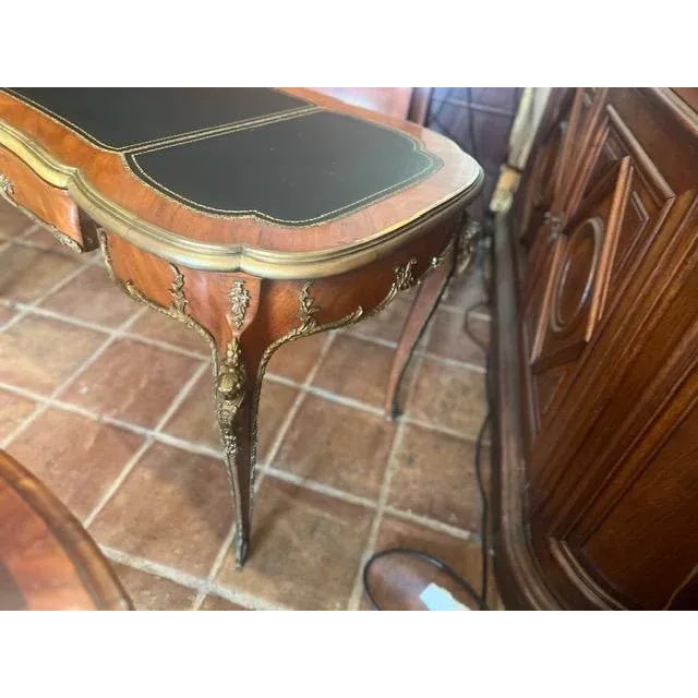 This antique French writing desk features a stunning mahogany finish with a green leather top, adding a touch of elegance...