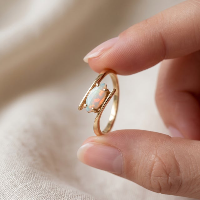 Adorn your hand with the magical luminescence of this bypass ring featuring a stunning marquise-cut White Opal. The gentle...