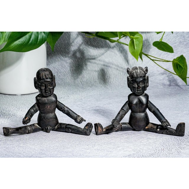 Discover a rare and evocative pair of antique hand-carved Chinese dolls. Crafted from dark hardwood with beautifully aged...