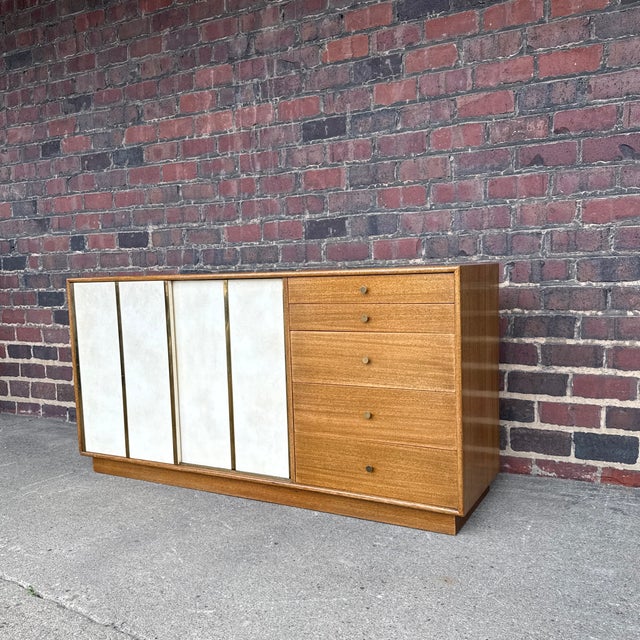 Harvey Probber Mid-Century Modern credenza or dresser crafted in mahogany with leather-front sliding panels and brass...