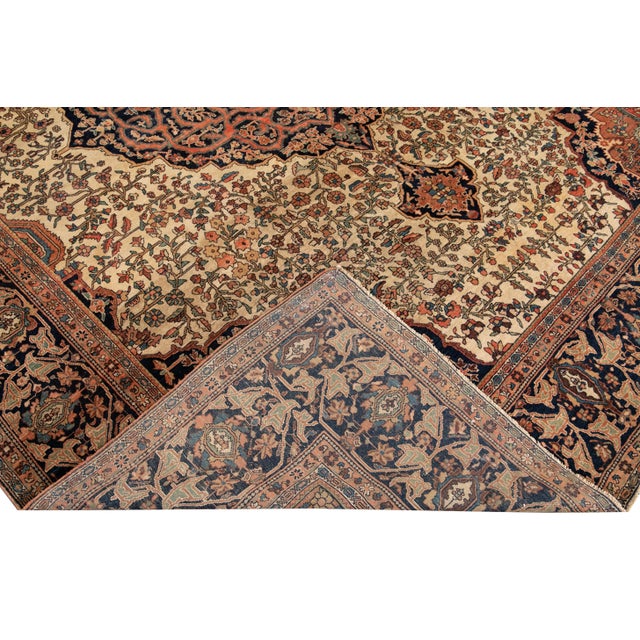 Beautiful Antique Sarouk Farahan hand-knotted wool rug with a beige field. This Farahan rug has a navy-blue frame and...