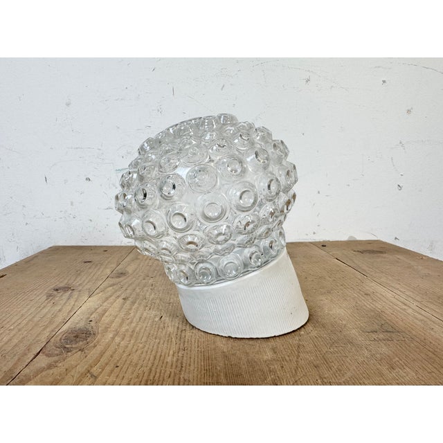 Vintage industrial light made in former Czechoslovakia the 1970s. It features a white porcelain wall mounting and a glass...