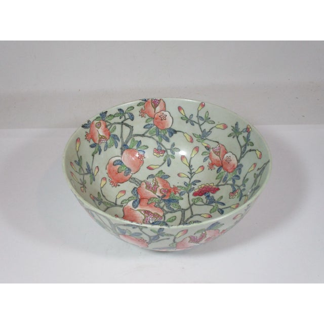 A large vintage porcelain hand painted Chinese bowl. This enamel painted bowl has a celadon background with all over...