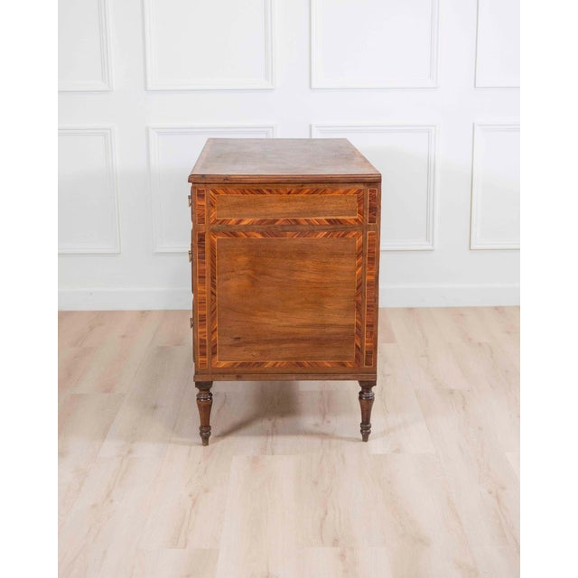 A refined Italian Louis XVI period chest of drawers, beautifully crafted in solid walnut and enriched with elegant...