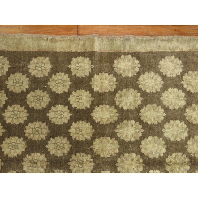 A mid-20th century Turkish Konya Intermediate size rug with repetitive circular motifs running on a brown colored ground....