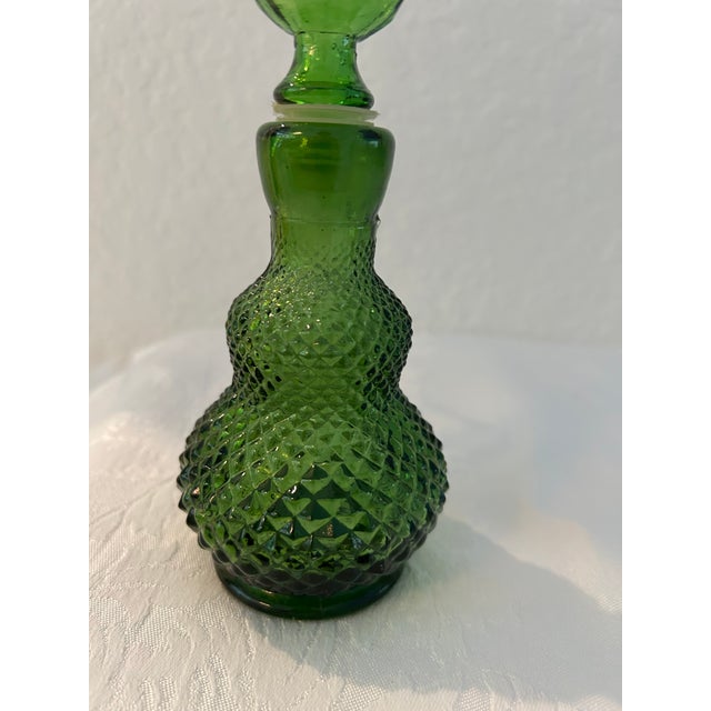 Lovely vintage green glass decanter in a diamond point design with twist off, hard plastic wrapped, glass stopper....