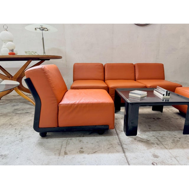 Five "amanta" modular armchairs by mario bellini for b&b italia in cognac-colored vegan leather with a black plastic base....