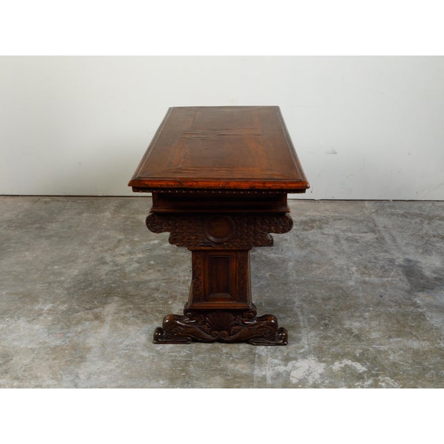 An Italian walnut table from the early 19th century, with carved motifs and two drawers. Created in Italy during the early...