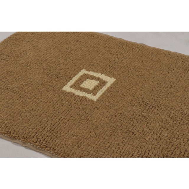 Hand-knotted in wool and originating from Turkey circa 1950-1960, this 4x5 vintage Tulu rug is a particularly rich and...