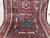 This Mamluk-style wool area rug features a rich red field with geometric medallions, detailed floral motifs, and...