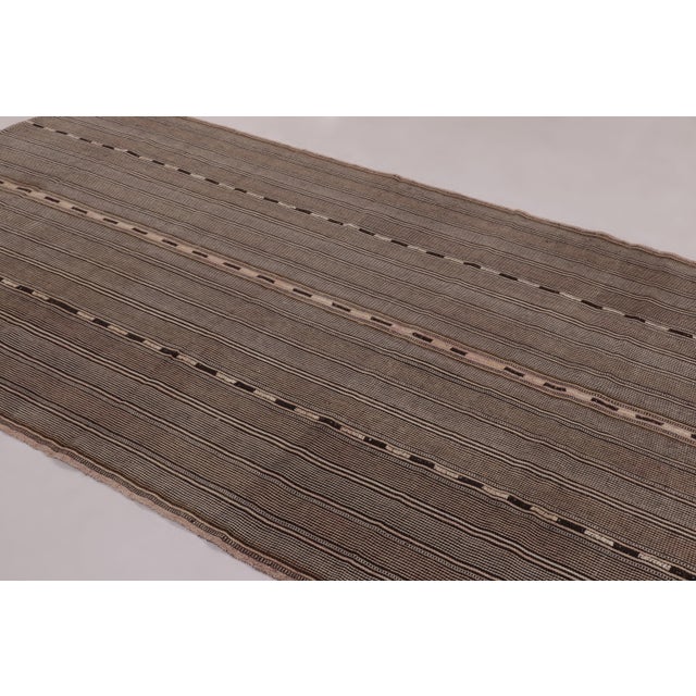 Made with handwoven wool circa 1950-1960, this 6x11 vintage kilim is a particularly intricate and sought-after work of an...