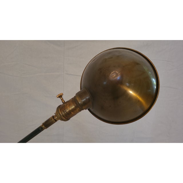 Very unique cast iron base floor lamp. Has a beautiful brass shade and tan braided fabric cord. Very adjustable with...