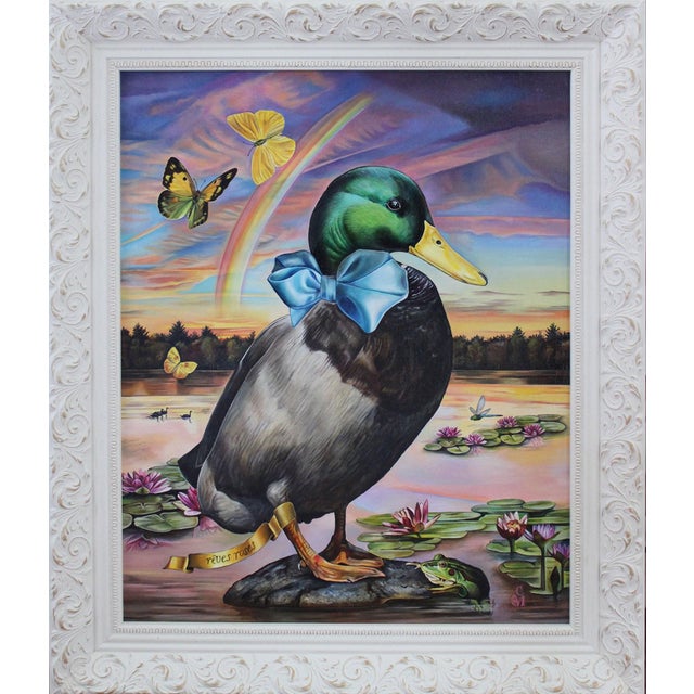 This artwork features a whimsical mallard duck adorned with a blue bow tie, poised atop a rock amidst a serene pond filled...