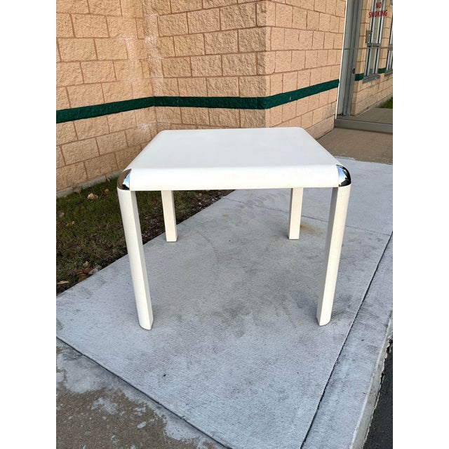 A square game table from the 1980s, wrapped in textured linen and finished in an ivory lacquer. Rounded waterfall edges...