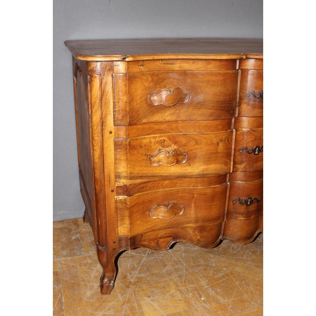 Three-drawer walnut commode with original iron keyhole escutcheons, original carved walnut drawer pulls, chapel-shaped...