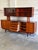 This two-piece sideboard and hutch features a striking architectural profile with an elevated glass display section. The...