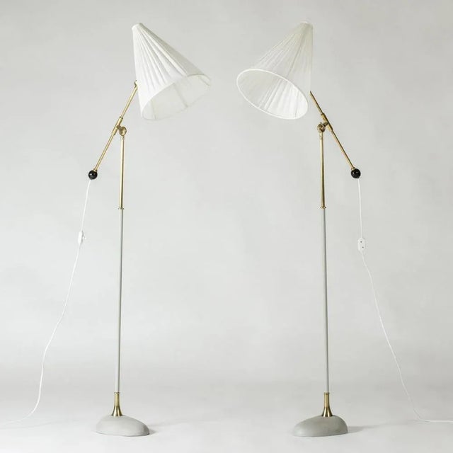 Pair of very cool floor lamps by Einar Bäckström, made from lacquered metal and brass. Chunky, oval bases lacquered light...