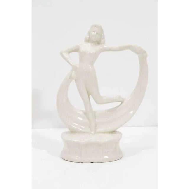 Art Deco dancing flapper ceramic sculpture features a delicate ivory craqueleur glaze. Dancer rests on a raised platform...