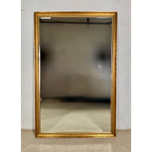 Elegant large Spanish wall mirror featuring a finely crafted giltwood frame with carved decorative mouldings and a warm...
