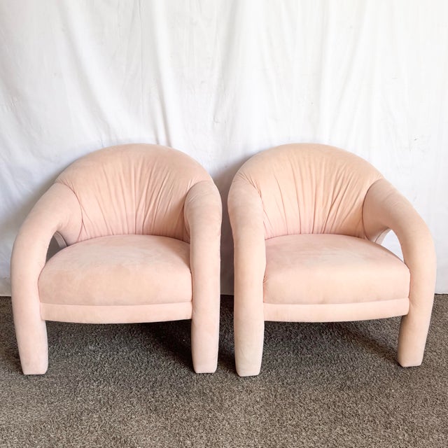 A striking pair of postmodern sculpted lounge chairs upholstered in a soft blush pink. Featuring bold, rounded silhouettes...