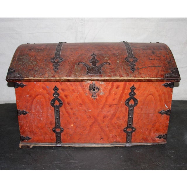 A Swedish 19th Century Orange Painted Chest with Wonderful Ironwork. This painted chest from Sweden is made from Wood and...