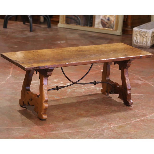 Crafted in Spain circa 1780, and built of solid walnut, the rectangular antique trestle coffee table stands on two carved...
