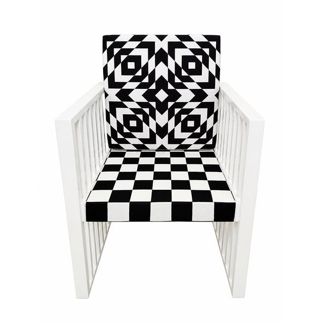 Armchair with a contemporary, geometric design, featuring a white lacquered frame with clean lines and vertical slat...