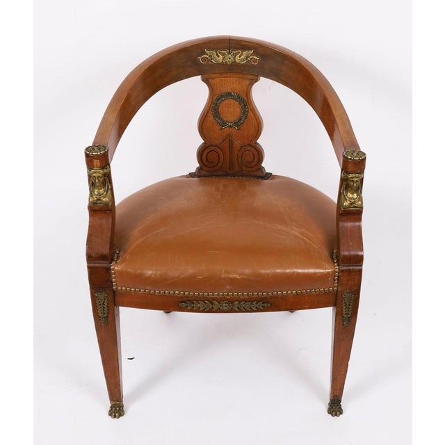 This is a fine antique French Empire Revival ormolu mounted mahogany armchair, Circa 1880 in date. The bow-shaped chair...