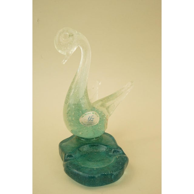 A delightful ashtray, embellished with a swan sculpture, made of sommerso pulegoso glass, green on the inside and clear on...
