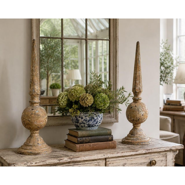 A striking pair of weathered cast iron garden finials with a beautifully aged surface and timeless architectural presence....