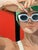 An array of primary colors! Shading her eyes from the sun with her hands and wearing her white sunnies, she exemplifies a...