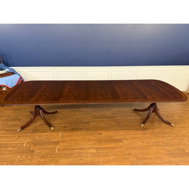 This is a traditional mahogany dining table made by Leighton Hall. It features a field of slip-matched swirly crotch...