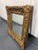 Ornate late 20th century wall mirror by John-Richard featuring an elaborately carved giltwood frame with scrolling...