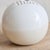 A 1960s Italian ceramic vase in creamy white glaze designed by Franco Bucci for Laboratorio Pesaro. The spherical...