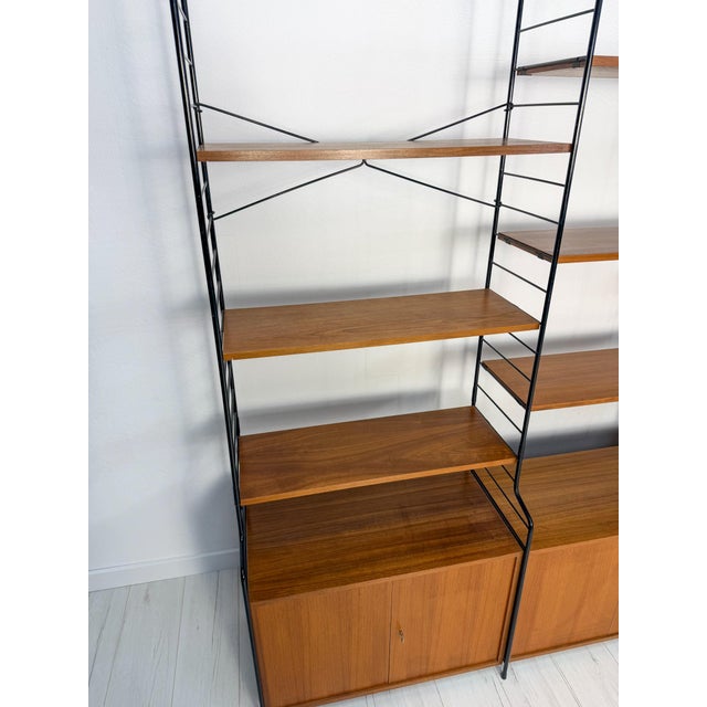 A charming wall unit designed and manufactured by whb in germany during the 1960s. It features a sleek black lacquered...