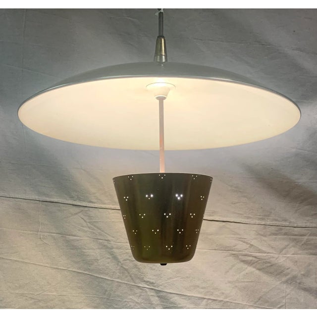Very elegante Perforated brass reflecting up to wide dome shade with white enameled bottom. Very Rare find. Paavo Tynell...