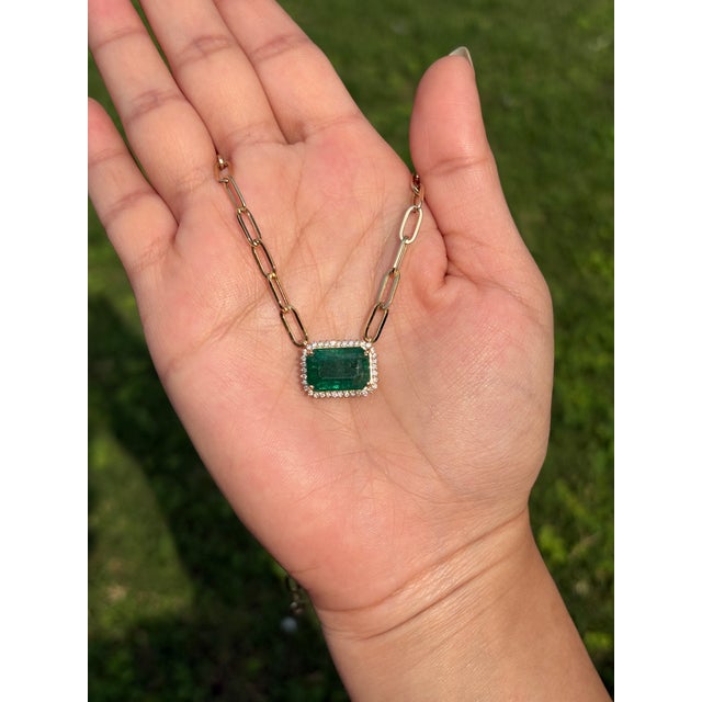 This pendant necklace features a 6.9 carat octagon natural emerald set in 14k yellow gold. The emerald measuring about...