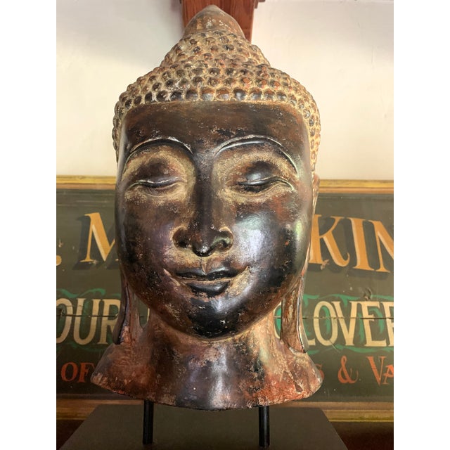 Massive statuesque Buddha on wood stand. Its gorgeous antique burnished brown patina will transport you each time you lay...